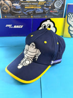 Casquette collector Michelin F1 neuve avec Bibendum et visière bleu marine bordée de jaune.