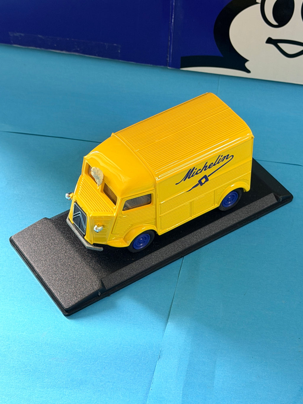 Vue trois quarts avant du Citroën Type H Michelin jaune Eligor 1/43 avec roues bleues et Bibendum.