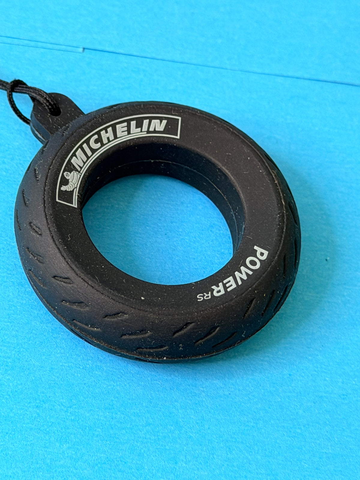 Gros plan du porte-clés pneu Michelin Power RS avec logo Michelin et Bibendum