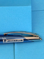 Détail du logo Michelin et Bibendum sur le corps du stylo bleu avec clip métallique chromé.