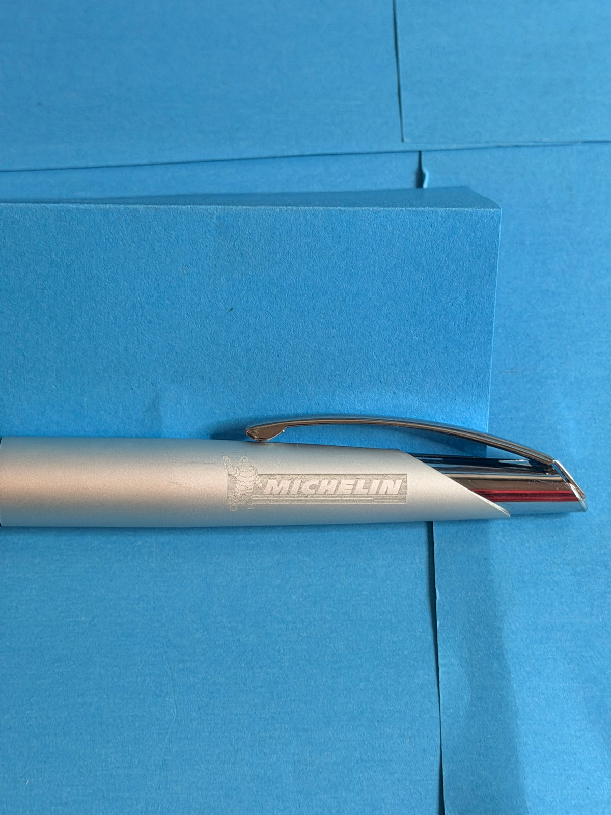 Gros plan sur la gravure Michelin et Bibendum du stylo métal argenté de collection.