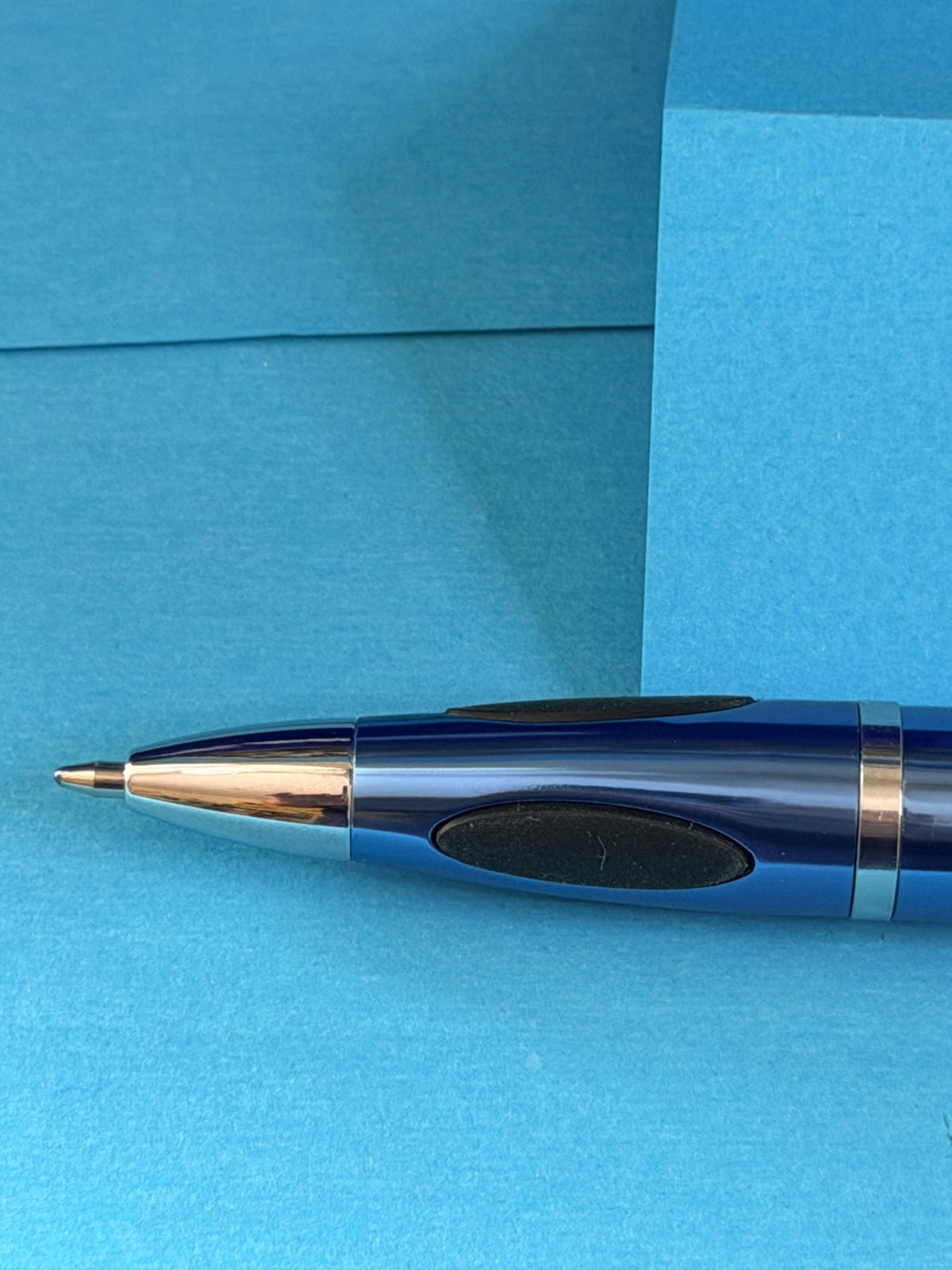 Détail de la pointe et de la zone de préhension du stylo Michelin bleu métallisé avec éléments chromés.
