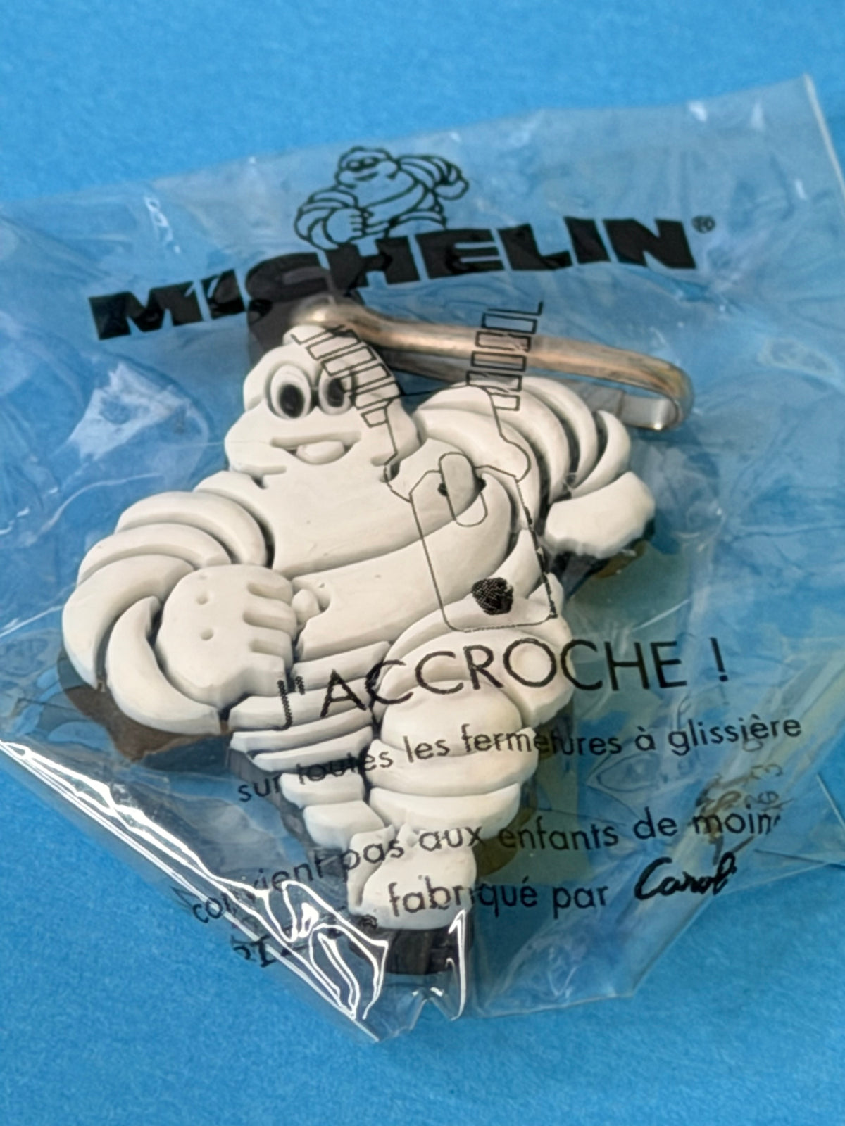 Gros plan sur le porte-clés Bibendum Michelin en relief et son emballage J’ACCROCHE