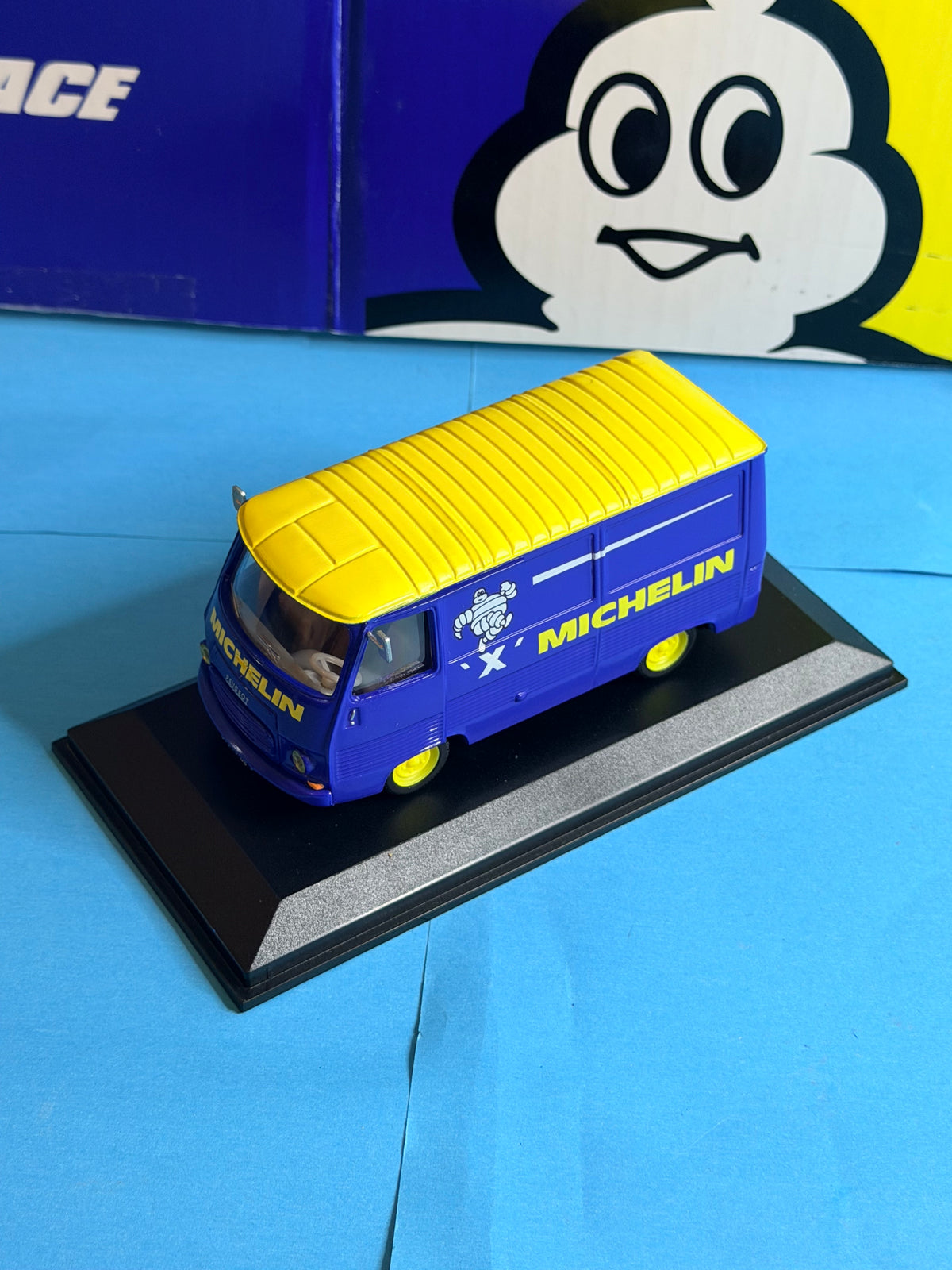 Vue latérale du Peugeot J7 Michelin Pneu X 1/43 avec carrosserie bleue, toit jaune et roues jaunes.