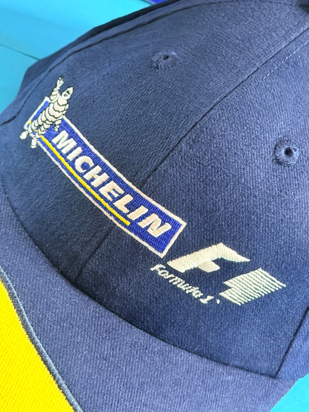 Détail des broderies Michelin et Formula 1 sur l’avant de la casquette F1 bleu marine.