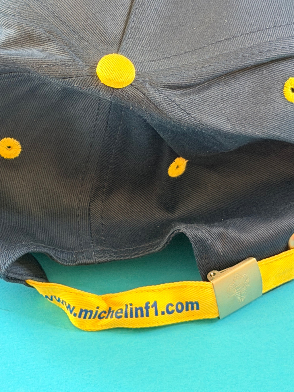 Sangle arrière jaune http://www.michelinf1.com avec boucle métallique Bibendum de la casquette Michelin F1.