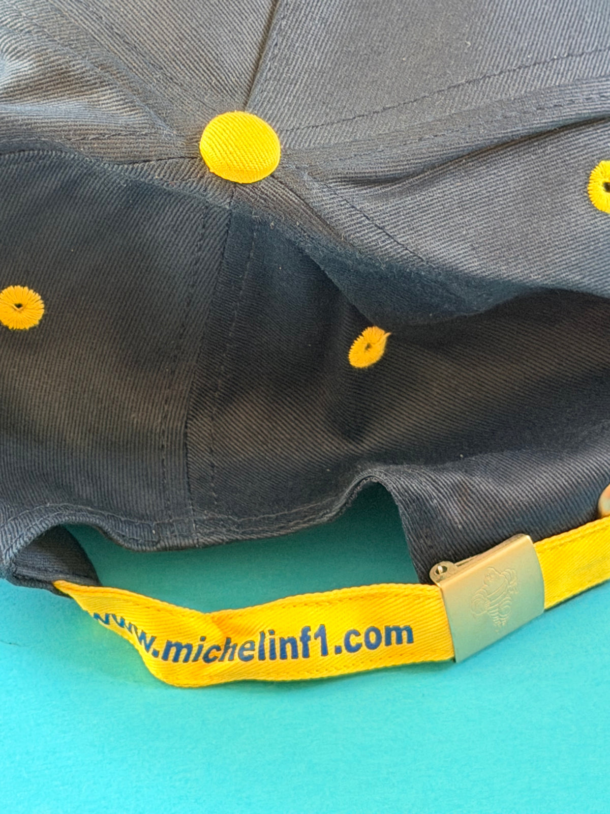 Sangle arrière jaune http://www.michelinf1.com avec boucle métallique Bibendum de la casquette Michelin F1.