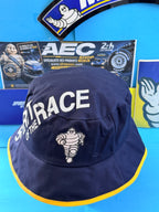 Bob Michelin Formula 1 neuf avec Bibendum et inscription Spirit of the Race, bleu marine et jaune.