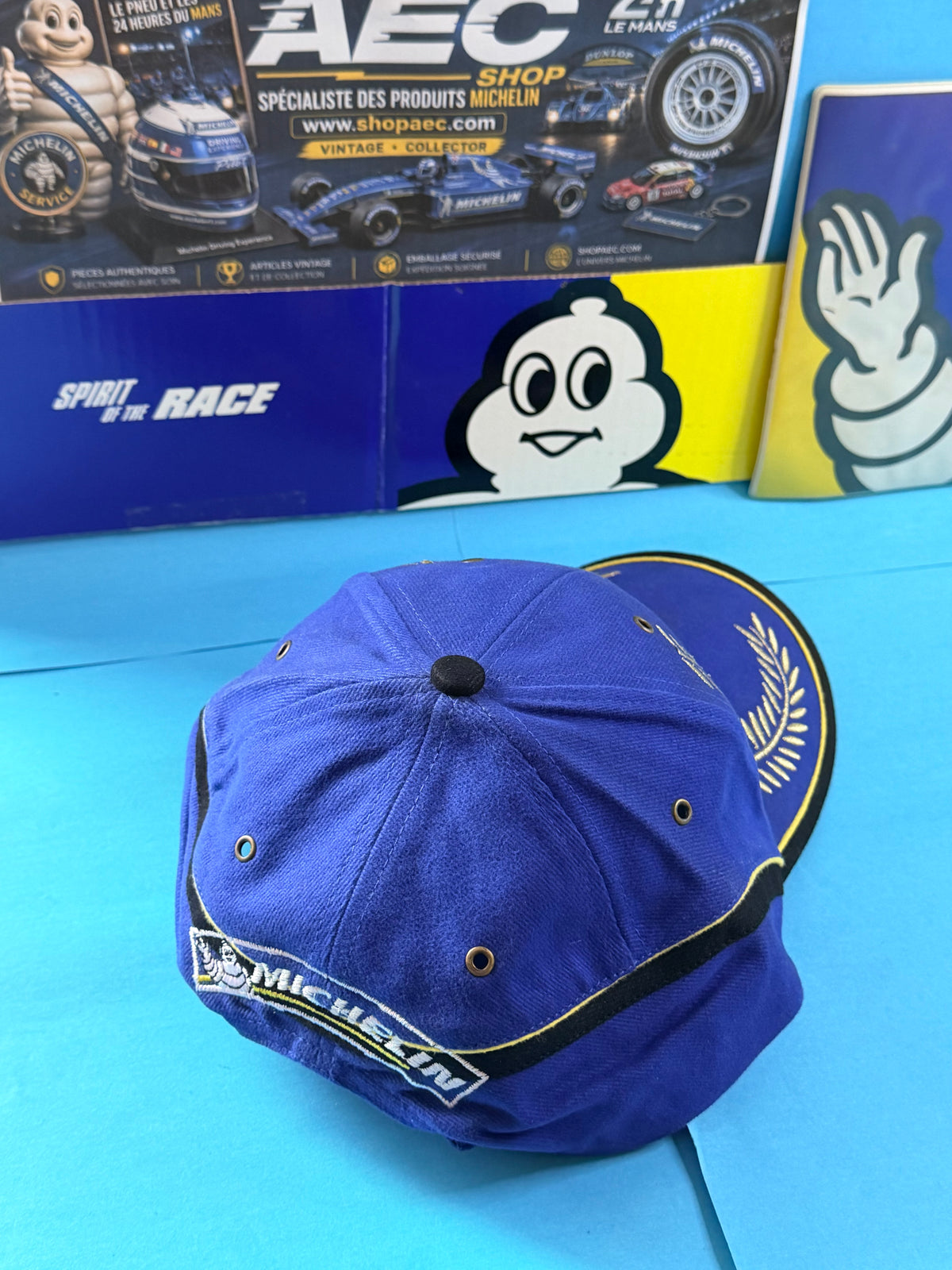 Vue arrière de la casquette Michelin Podium bleue neuve montrant le marquage Michelin brodé et les finitions noires et jaunes.
