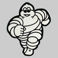 Autocollant publicitaire Michelin représentant Bibendum allongé, silhouette découpée noir et blanc, objet de collection de 8,5 × 7 cm.