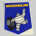 aAutocollant Michelin vintage bleu et jaune avec Bibendum saluant et tenant un pneu, fabrication britannique.