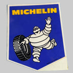 aAutocollant Michelin vintage bleu et jaune avec Bibendum saluant et tenant un pneu, fabrication britannique.