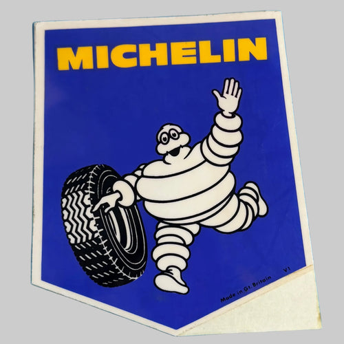 aAutocollant Michelin vintage bleu et jaune avec Bibendum saluant et tenant un pneu, fabrication britannique.
