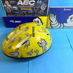Casque Michelin Bibendum jaune brillant avec aérations et illustrations publicitaires, vue de côté.