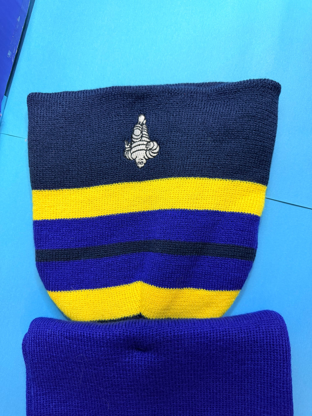 Détail du Bibendum Michelin brodé sur l’ensemble textile Collector bleu et jaune