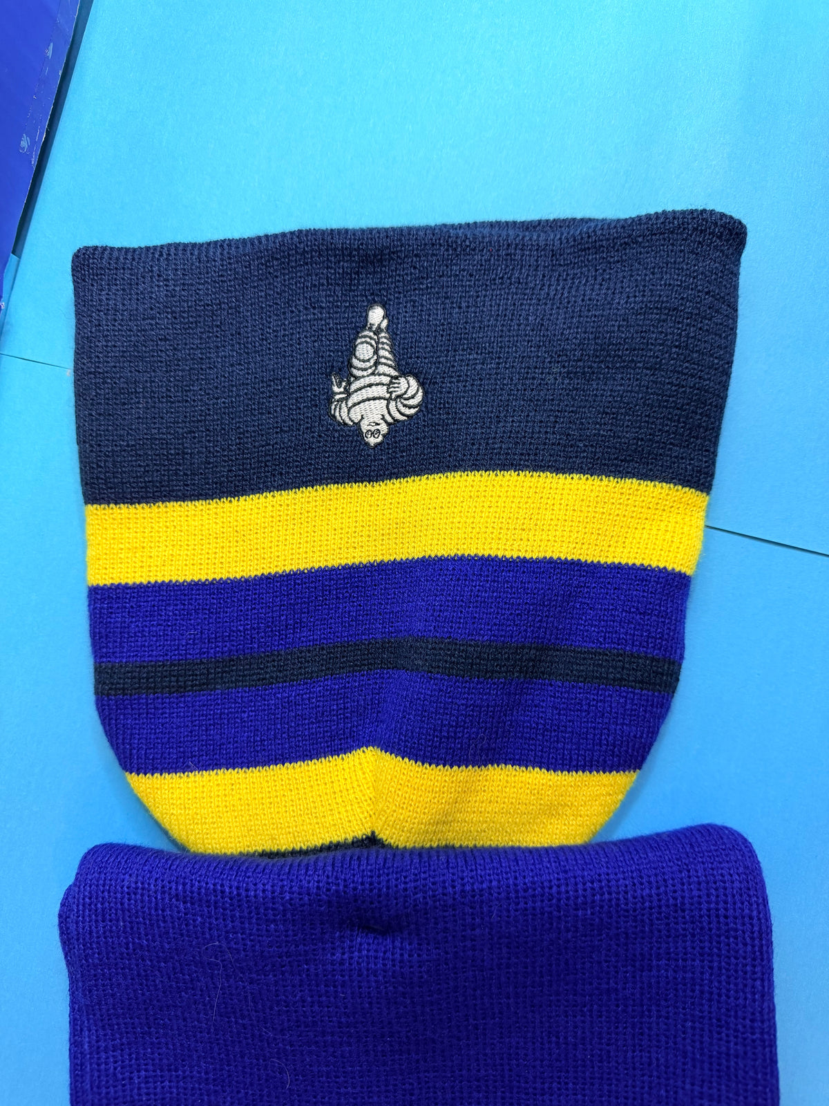 Détail du Bibendum Michelin brodé sur l’ensemble textile Collector bleu et jaune