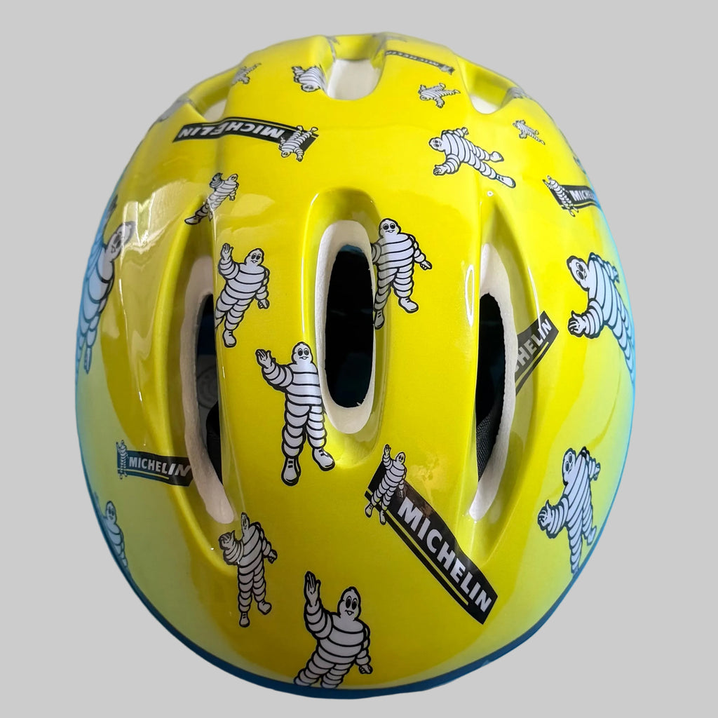 Casque de vélo Michelin jaune taille L, décoré de nombreux Bibendum et logos Michelin, vue de face.