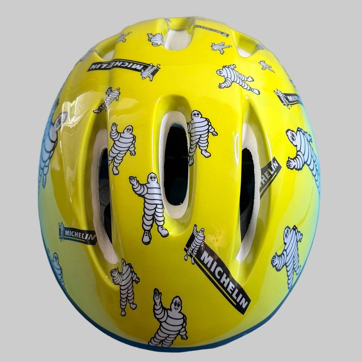 Casque de vélo Michelin jaune taille L, décoré de nombreux Bibendum et logos Michelin, vue de face.