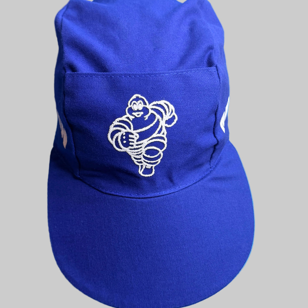 Casquette Michelin vintage bleue avec Bibendum blanc sérigraphié sur l’avant et large visière.