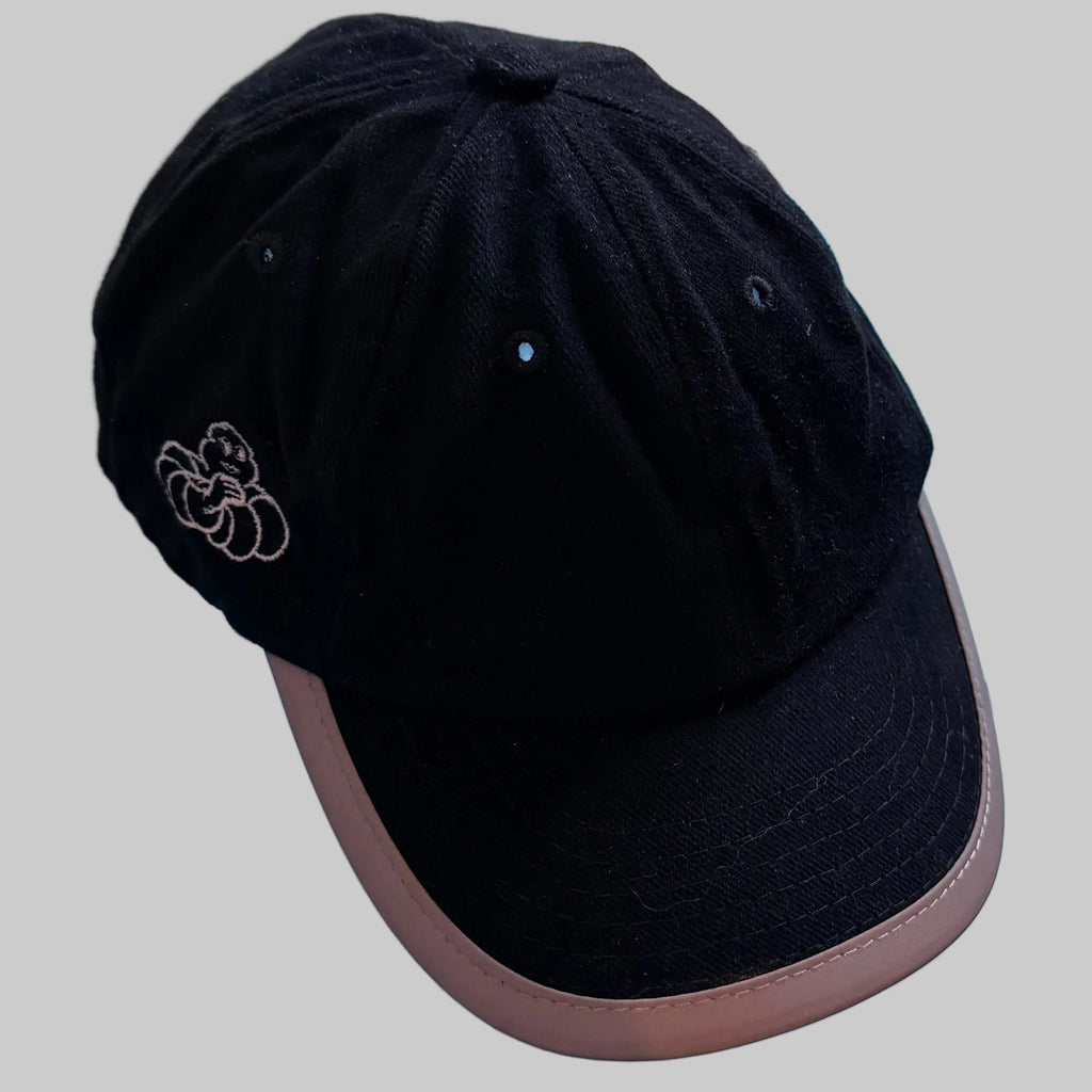 Casquette Michelin noire avec visière incurvée à bordure beige et Bibendum brodé sur le côté.