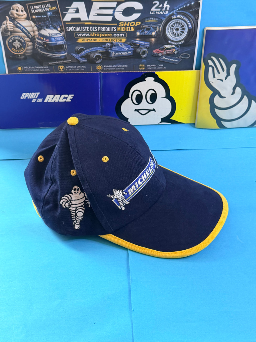 Vue latérale casquette Michelin Formula 1 montrant les broderies Bibendum et le liseré jaune de la visière