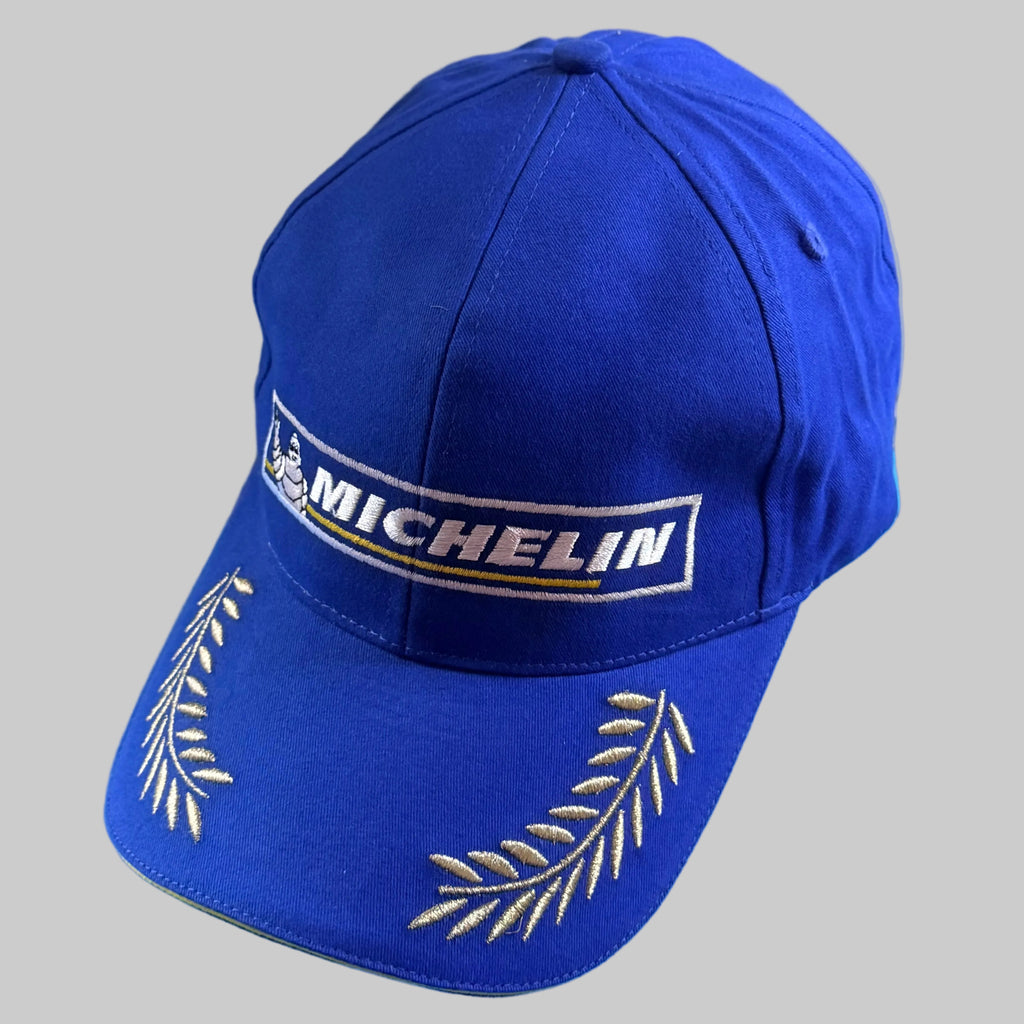 Casquette Michelin Podium neuve bleu et jaune avec Bibendum, logo Michelin et lauriers brodés sur la visière. Modèle collector pour passionnés.