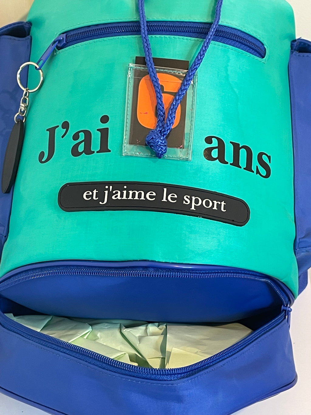 Vue arrière et latérale du sac à dos enfant montrant les bretelles et les différents espaces de rangement.