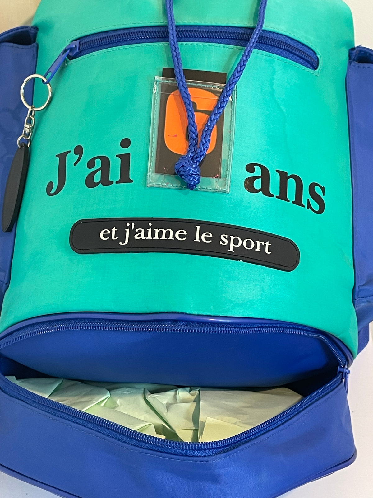Vue arrière et latérale du sac à dos enfant montrant les bretelles et les différents espaces de rangement.