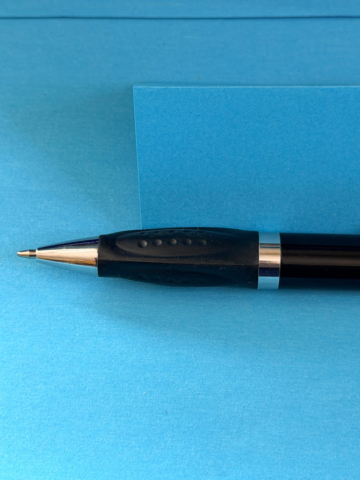 Détail de la pointe et du grip noir du stylo à bille Michelin avec mine neuve.
