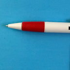 Détail de la pointe et de la zone de préhension rouge texturée du stylo Kleber