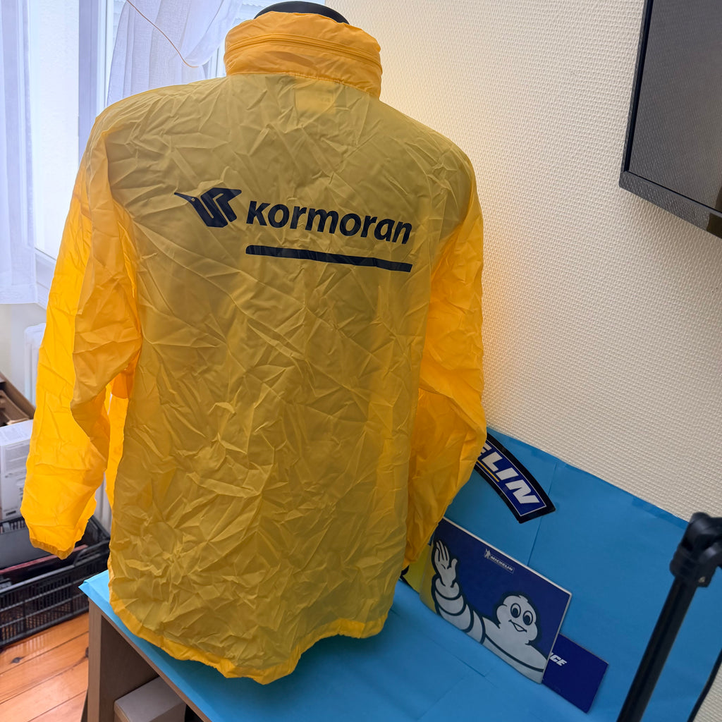 Dos du coupe-vent Kormoran jaune avec grand logo bleu de la marque de pneumatiques.