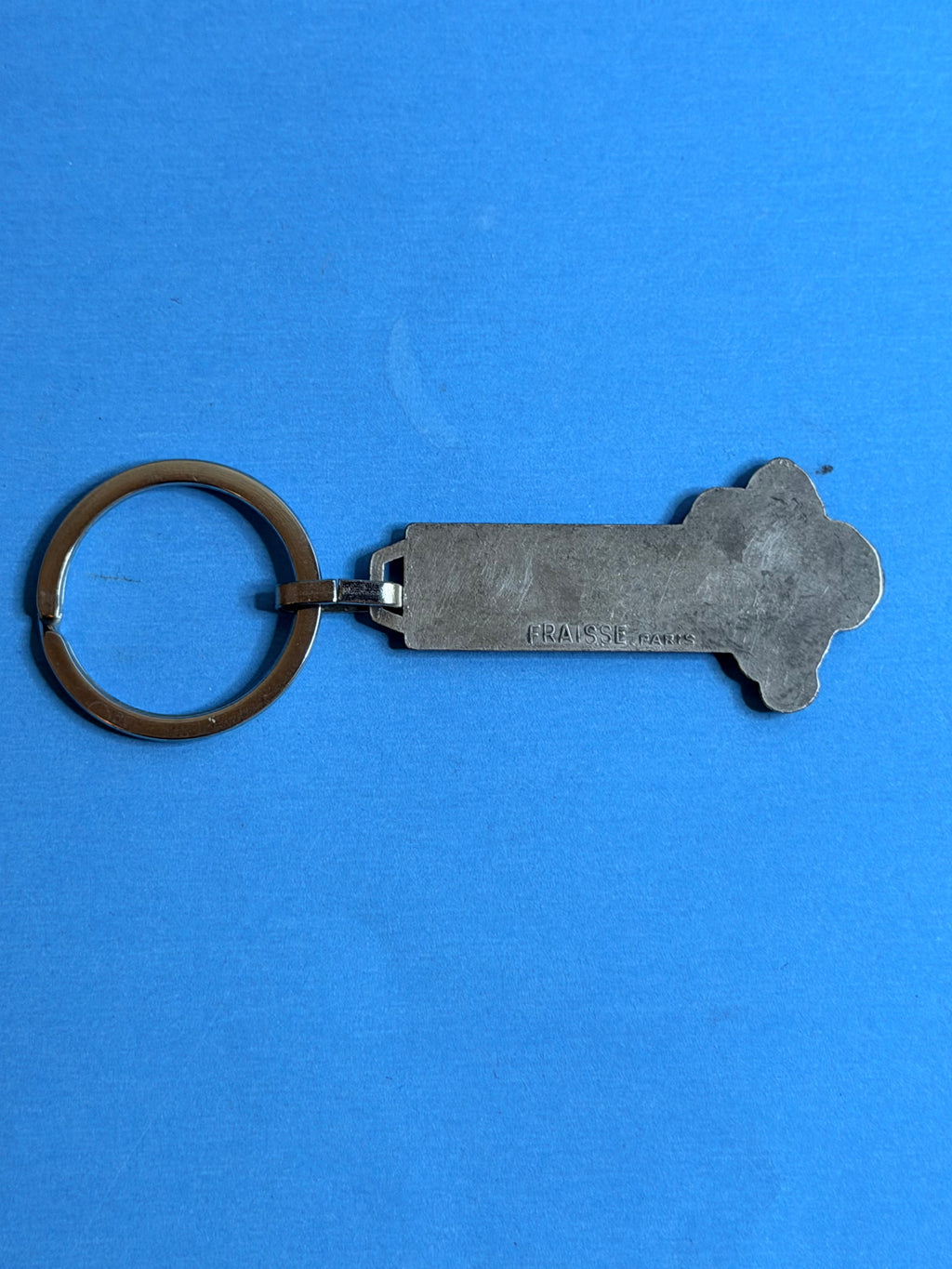 Dos du porte-clés Michelin Bibendum vintage en métal avec marquage du fabricant FRAISSE PARIS.