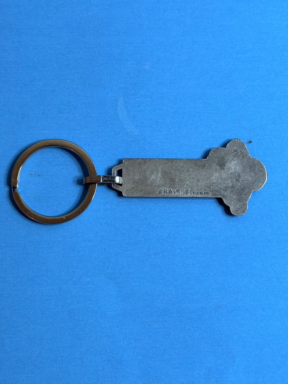 Dos du porte-clés Michelin Bibendum vintage en métal avec marquage du fabricant FRAISSE PARIS.