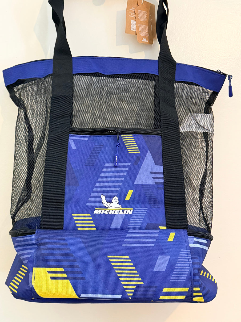 Dos du sac de sport Michelin avec poche zippée, filet noir et motifs bleus et jaunes.