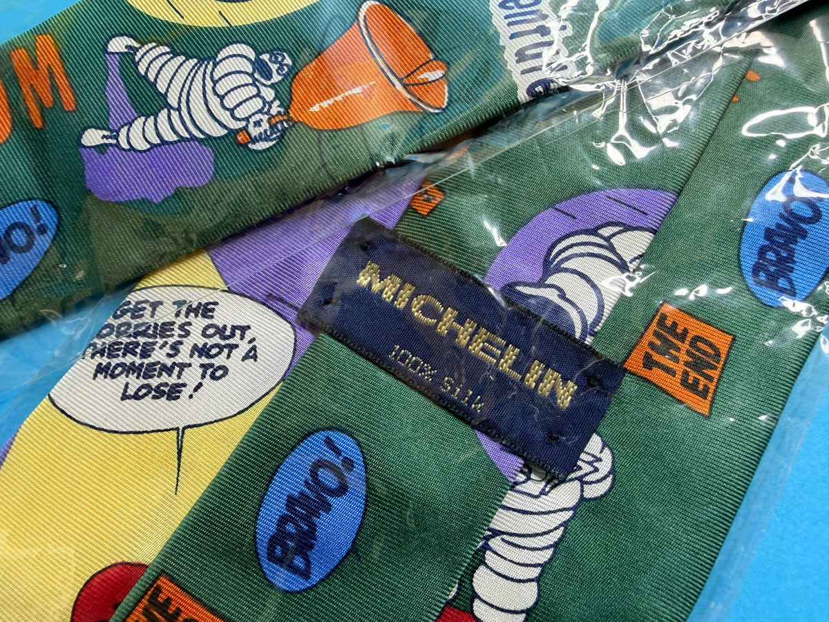 Détail des motifs Bibendum et Michelin sur cravate vintage en soie
