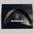 Gratte-pare-brise publicitaire Michelin noir avec logo blanc et illustration du Bibendum sur la face avant.