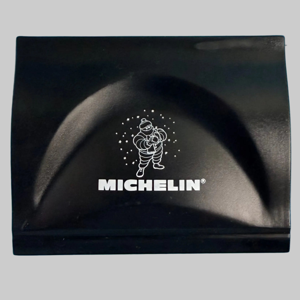 Gratte-pare-brise publicitaire Michelin noir avec logo blanc et illustration du Bibendum sur la face avant.