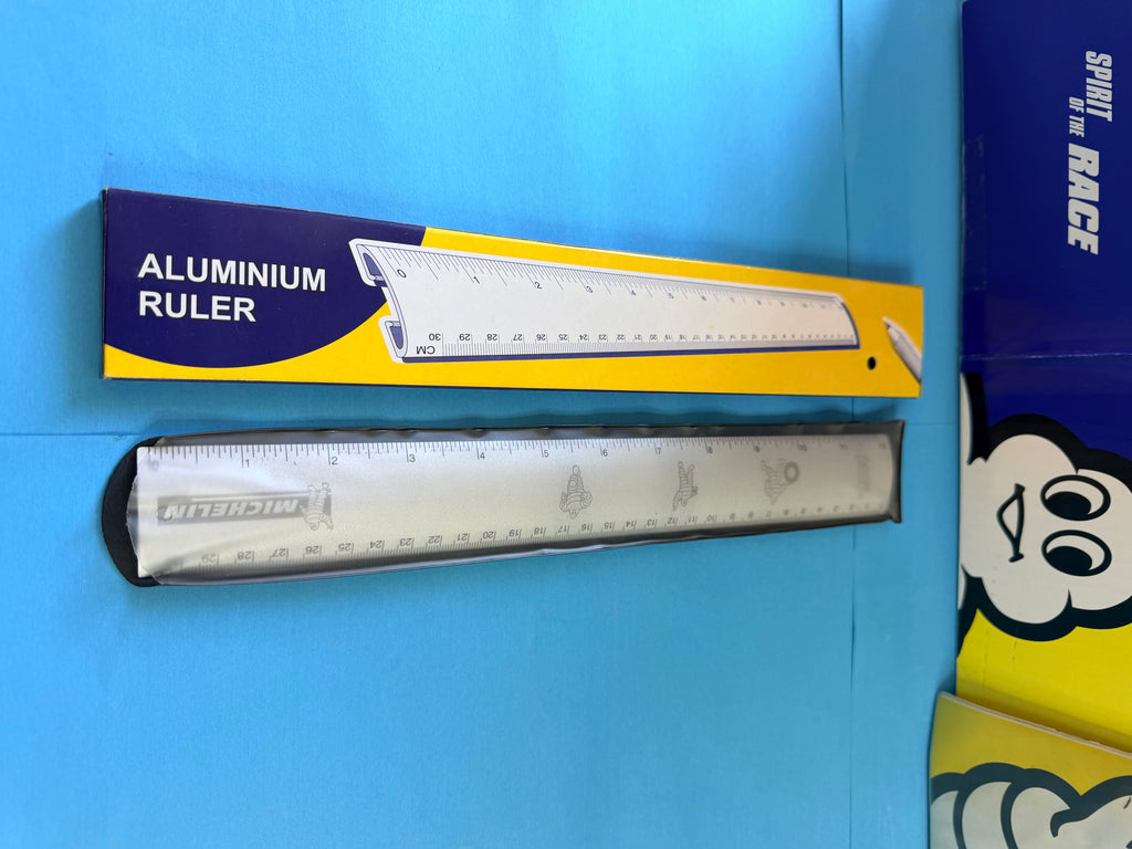 Détail de la règle Michelin en aluminium avec illustrations Bibendum et logo Michelin