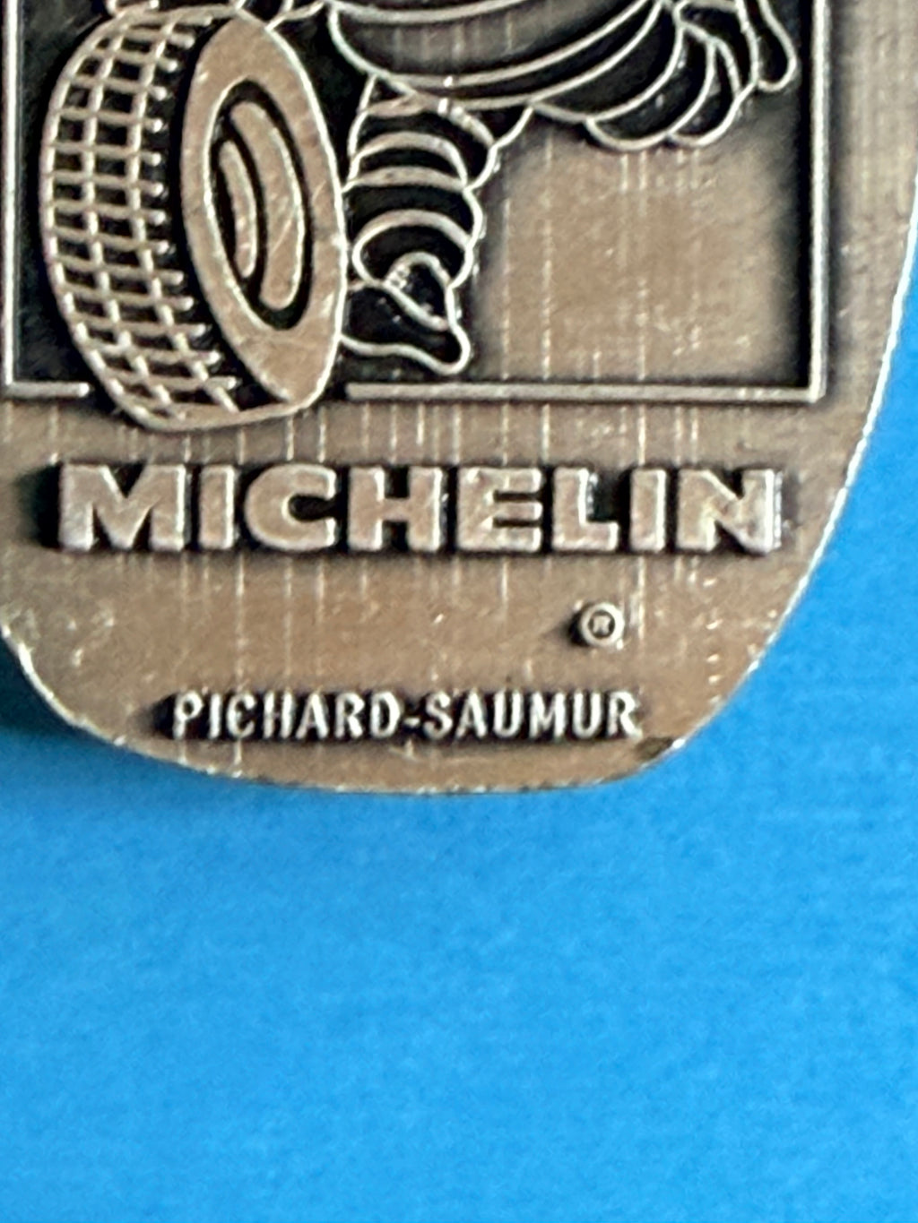 Gros plan du pendentif pneu Michelin en métal du porte-clés vintage Pichard SA