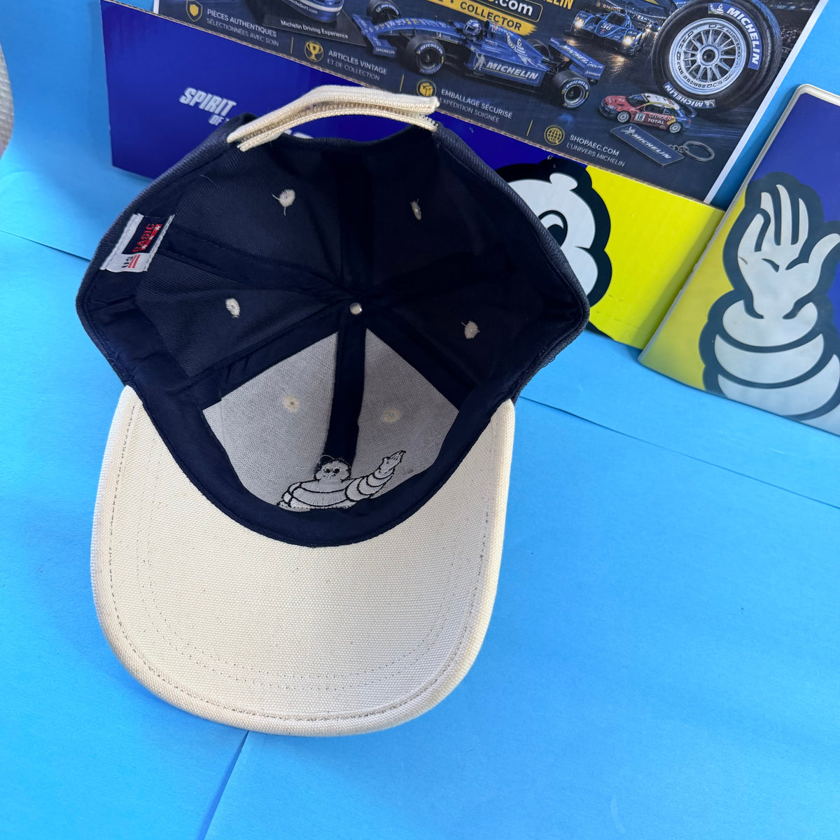 Intérieur de la casquette Michelin avec doublure de visière écrue, broderie Bibendum et étiquette textile.