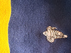 Détail du Bibendum Michelin brodé sur l’ensemble textile Collector bleu et jaune et bleu