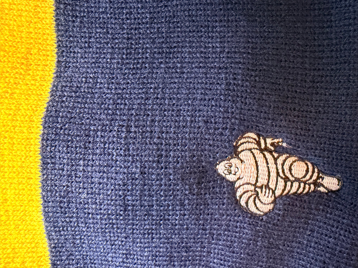 Détail du Bibendum Michelin brodé sur l’ensemble textile Collector bleu et jaune et bleu