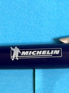 Gros plan du logo Michelin et de Bibendum sur stylo publicitaire bleu de collection