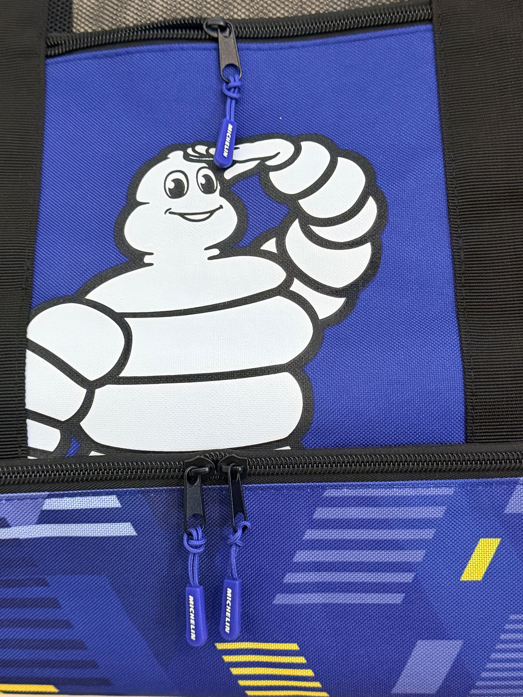Logo Bibendum Michelin sur poche bleue avec fermetures éclair.