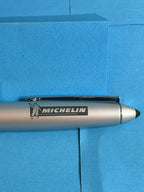 Vue complète du stylo Michelin argenté avec grip noir, finitions chromées et logo Bibendum.