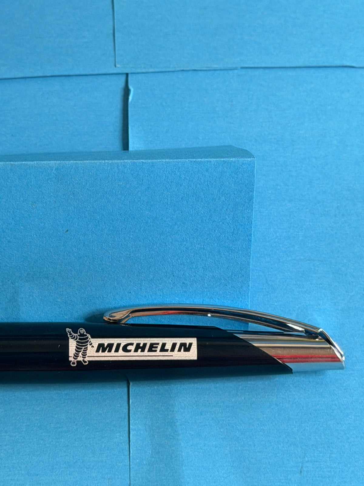 Gros plan sur le logo Michelin et Bibendum apposé sur le corps noir du stylo de collection.