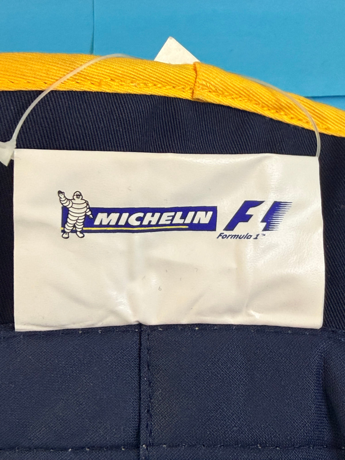 Étiquette Michelin F1 Formula 1 à l’intérieur du bob officiel bleu marine et jaune.