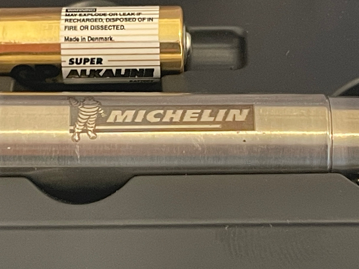 Détail du corps métallique et du logo Michelin sur lampe torche de collection