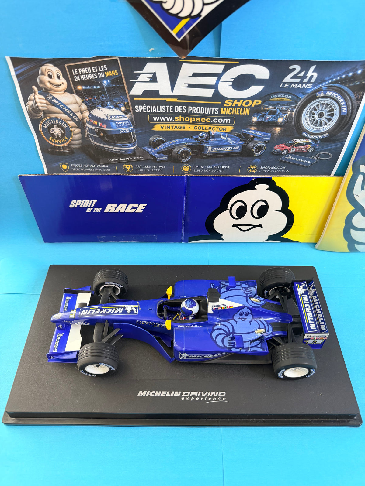 Formule 1 Michelin Driving Experience Spirit of the Race échelle 1/18 avec décoration Bibendum bleu, présentée sur son socle Michelin.