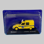 Miniature Citroën Acadiane Michelin jaune à l'échelle 1/43, avec Bibendum sur le toit et présentation dans son boîtier transparent.